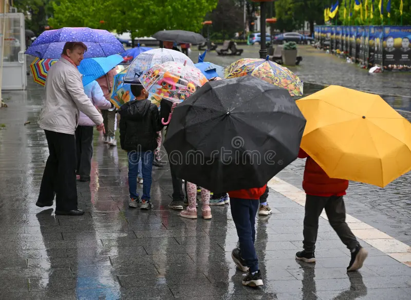 ucrania-de-mayo-los-paraguas-coloridos-alegran-un-día-lluvia-mientras-la-gente-camina-por-una-calle-ciudad-409023695